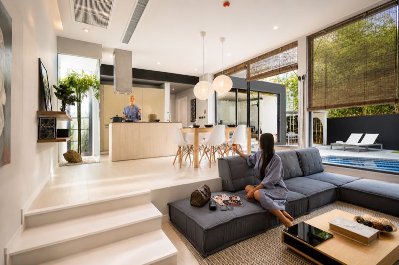 Open plan living and dining area of a villa in Thailand, opening onto the pool