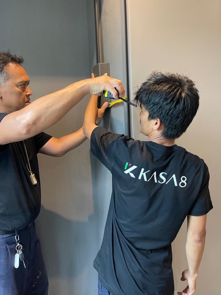 Two members of the Kasa8 team measuring and fitting a panel on site